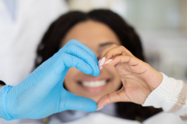 Closeup Of Dentist Doctor And Female Patient Making Heart Gesture With Hands