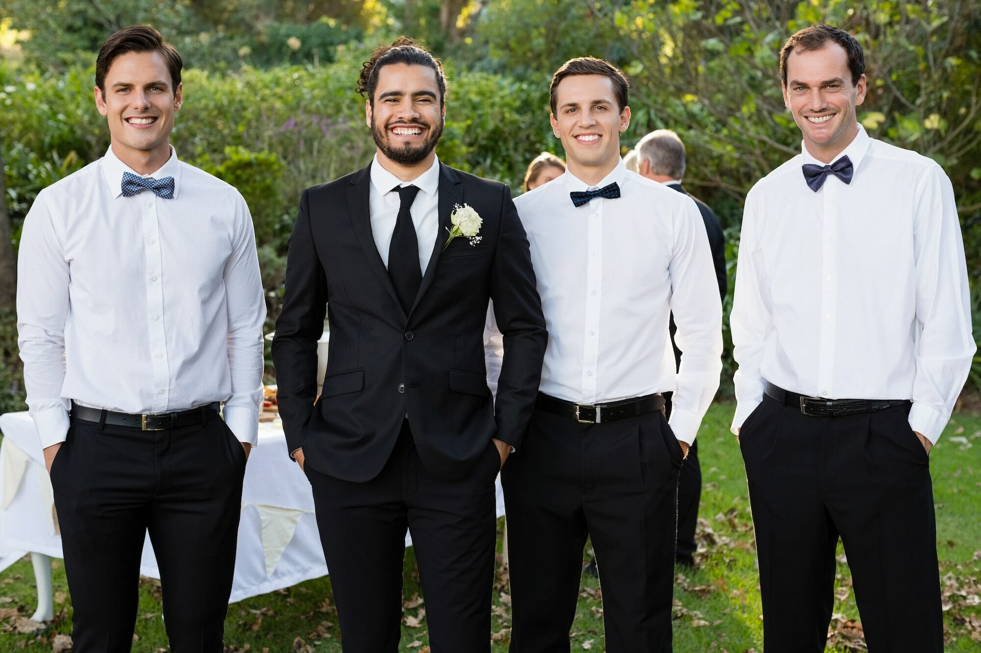 Portrait of groom and groomsmen standing with hands in pocket