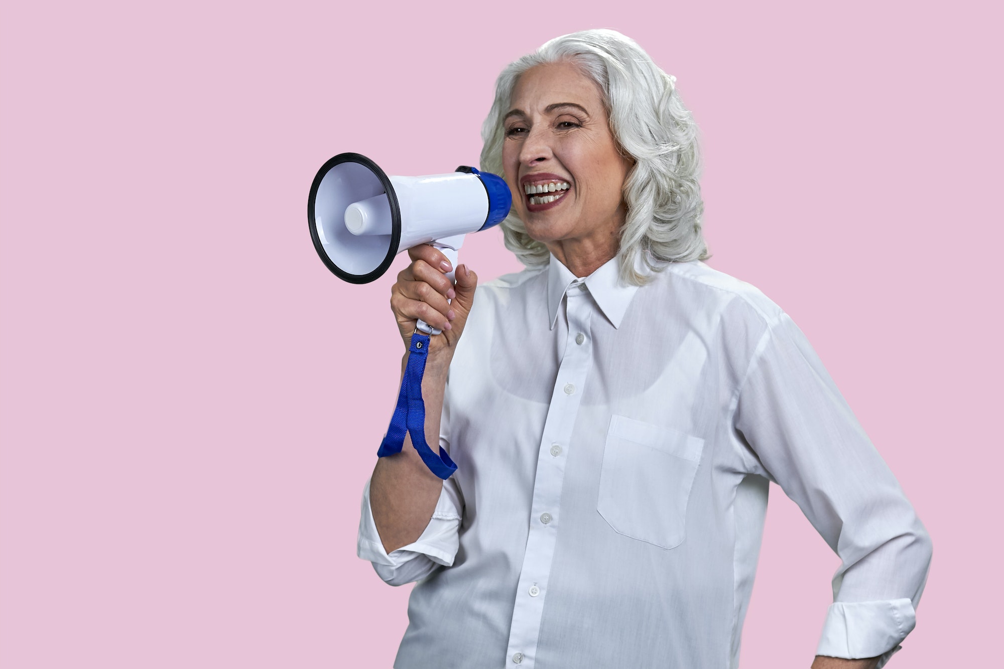 Portrait of laughing senior woman with megaphone.